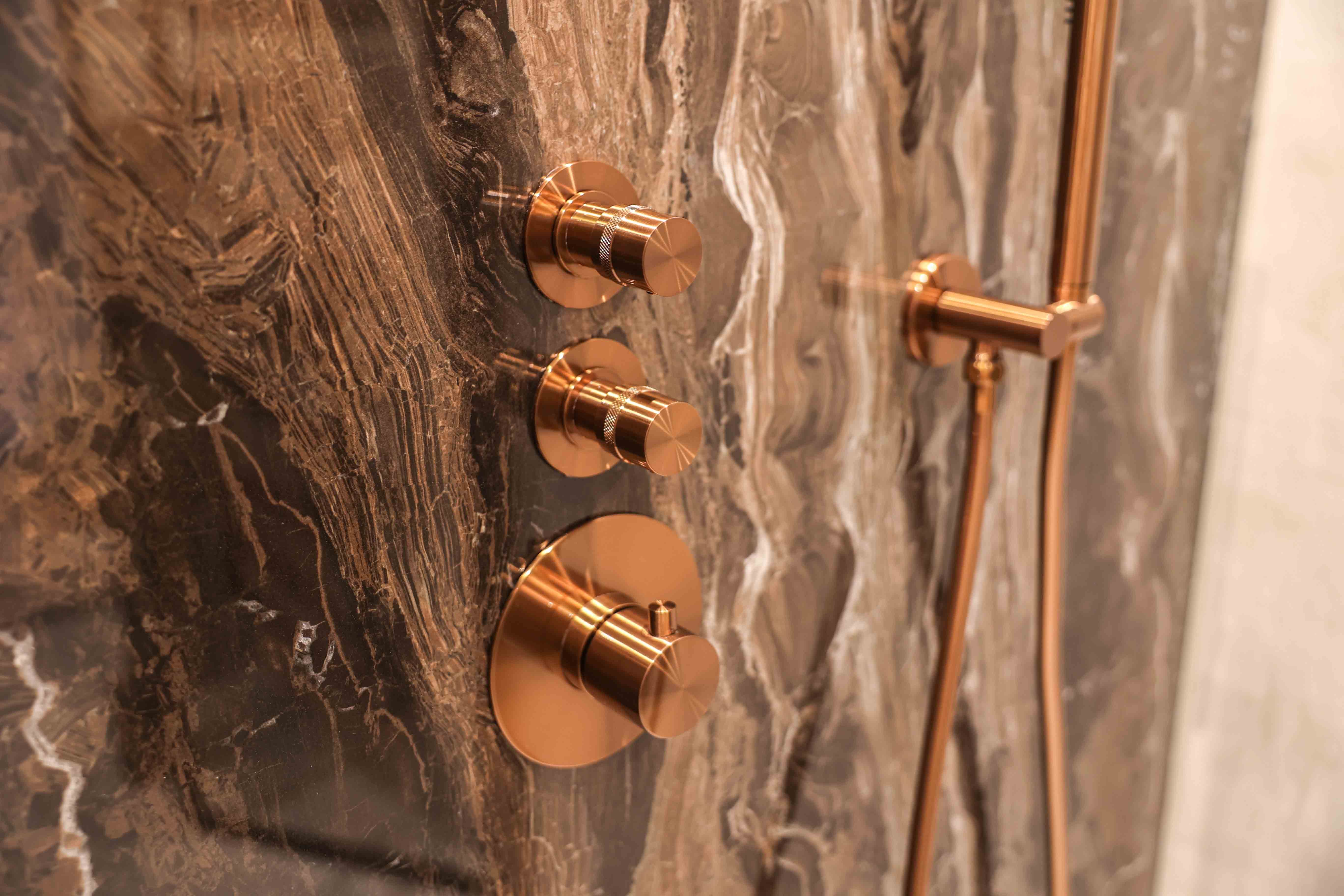 Brauer Copper Carving thermostaatkranen in geborsteld koper op bruin marmerlook wand