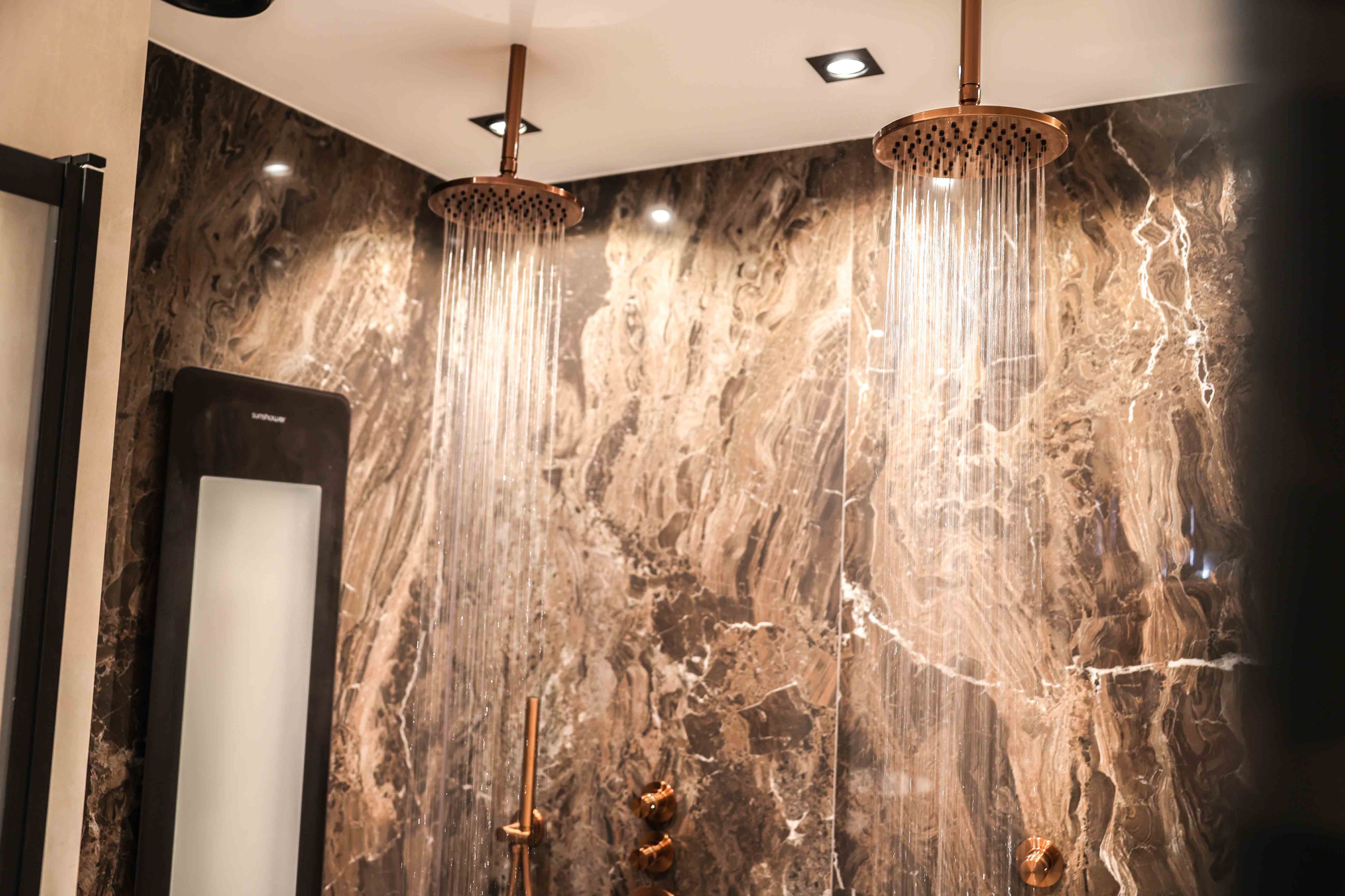 Hotel-chic badkamer van Ray en Ros uit Druten met dubbele regendouche en bruin marmerlook tegels