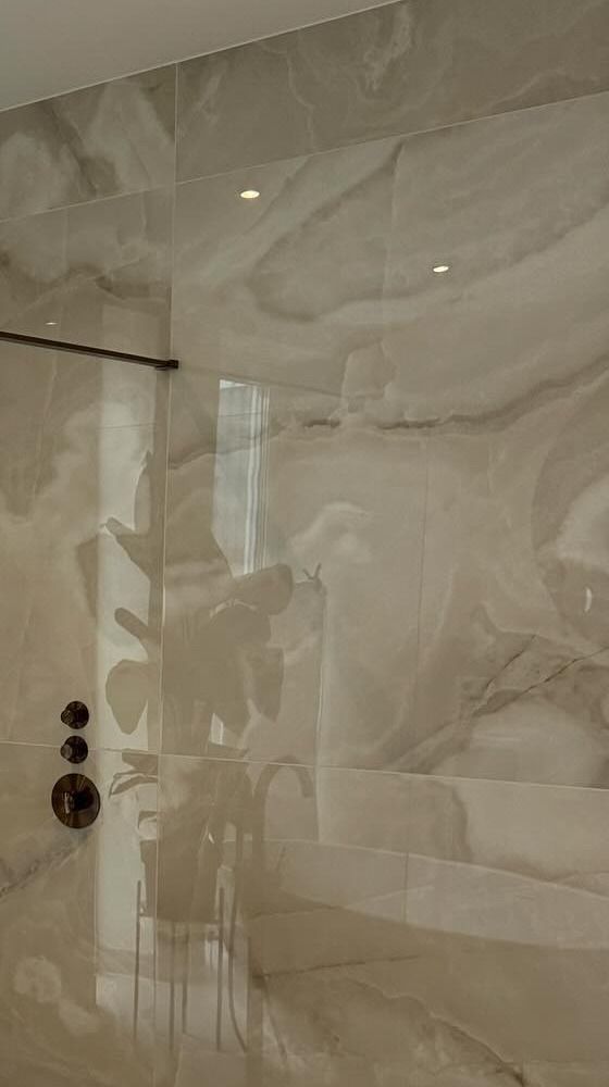 Onyx-look wandtegels met koperen thermostaatkraan