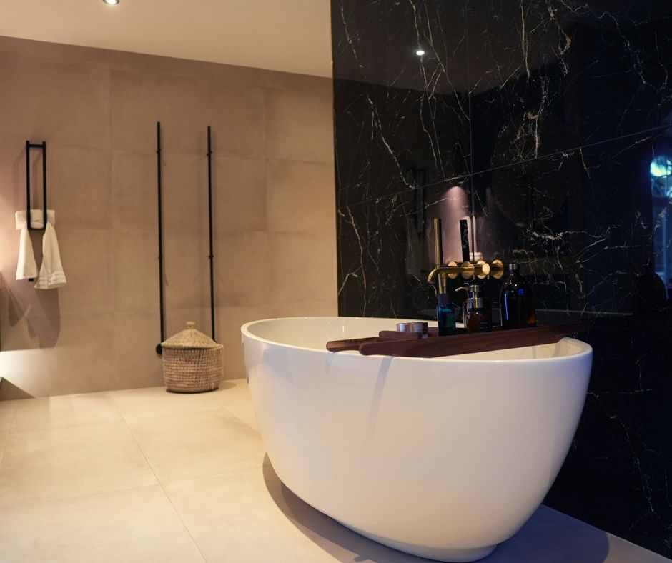 Moderne badkamer van Kosso met zwart-witte marmerlook tegels en een ovaal vrijstaand ligbad